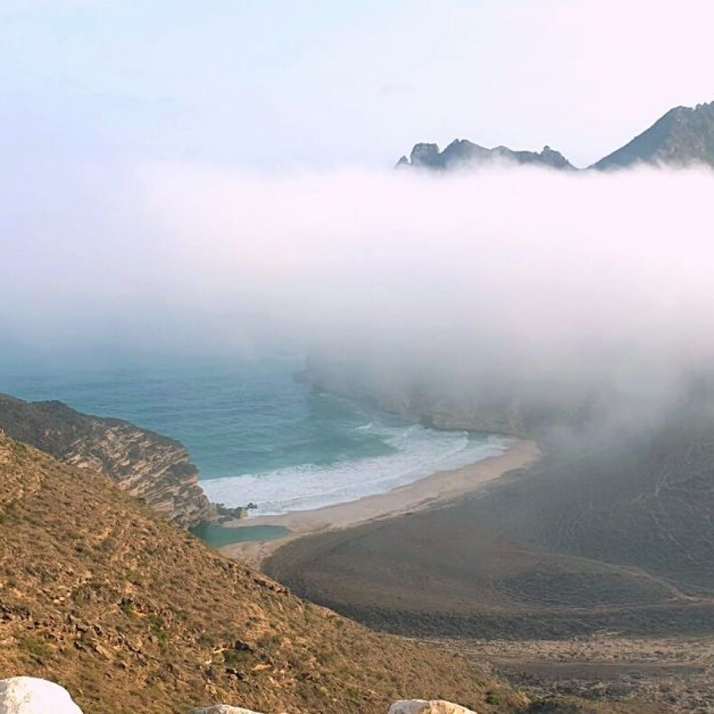 Clouds touching the mountains of Masood Hidden Beach Salalah
